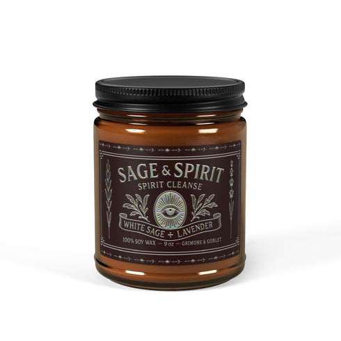 A high-quality studio photograph of the Grimoire & Goblet White Sage & Lavender candle. The 9 oz or 4 oz amber-colored glass jar is cylindrical with a smooth, black metal lid. The ornate, detailed label features the brand's name, 'Sage & Spirit,' an all-seeing eye, and the scent notes 'White Sage + Lavender.' The 100% soy wax blend and cotton wick are visible, crafted for a long-burning, clean, and elegant home fragrance. This piece of gothic home decor is a spiritual tool for energy cleansing.